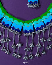 A focused view of the Sukoon waterfall boho necklace, showcasing its cascading silver-toned chains and enamel accents in soothing green and blue tones. The design highlights its earthy elegance and statement-making boho appeal — Muselot.