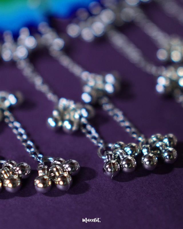 A close-up shot of the Sukoon waterfall boho necklace, zooming in on the layered chains and delicate gungroo details. The intricate silver-toned links and tiny bells showcase its graceful movement and traditional charm — Muselot.