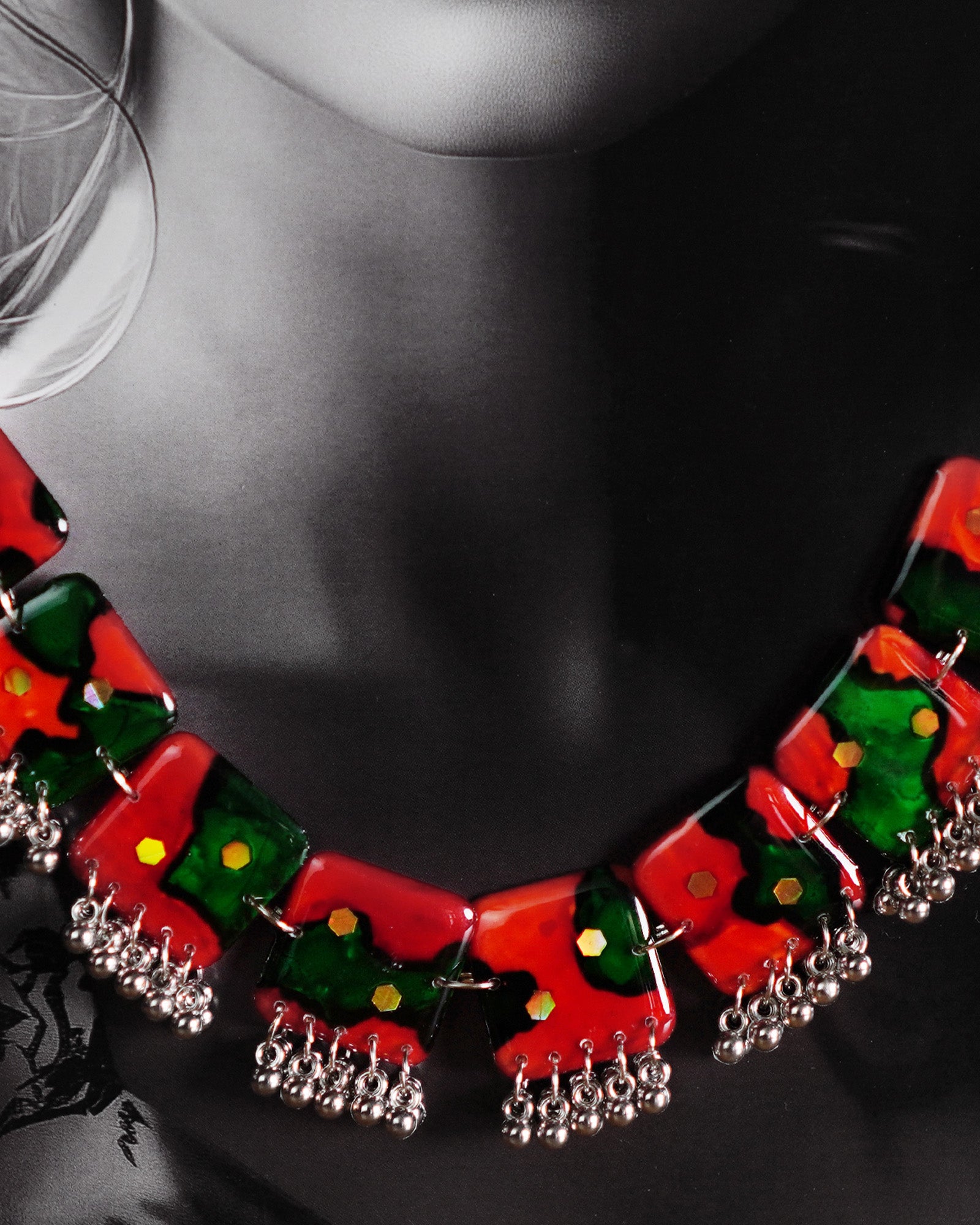 A model showcases the complete Surkhbaagh handmade jewelry set, including the vivid red-and-green block necklace and matching earrings, both accented with mirror sequins and delicate silver-toned beads. The set stands out against the outfit, highlighting its artistic flair and making it perfect for festive and cultural occasions — Muselot.