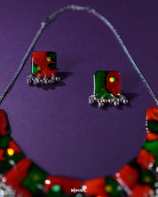 Close-up of the Surkhbaagh handmade earring showcasing oxidized silver detailing, mirror accents, and deep maroon beadwork that reflect ethnic charm with a bold, artisanal edge — Muselot.