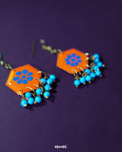 Surkhshaam orange floral stud drop earrings, set against a soft backdrop, with vivid blue petals and a delicate drop design that exude a lively and sophisticated boho charm — Muselot.