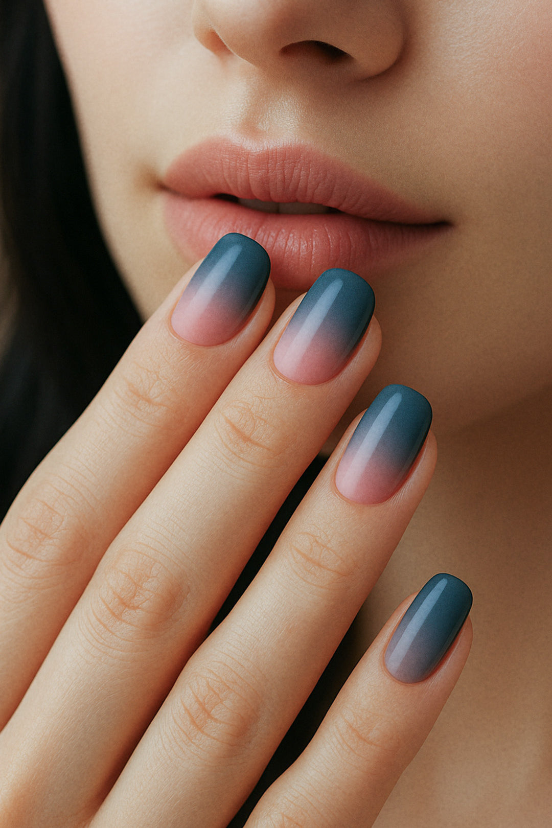 A model’s hand showcasing Twilight Rose Ombre nail stickies, featuring a chic gradient blend from deep teal-blue to soft blush pink, highlighting the smooth ombre transition and glossy salon-style finish – Muselot.