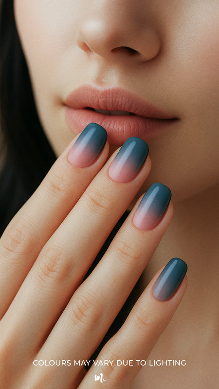 A model’s hand showcasing Twilight Rose Ombre nail stickies, featuring a chic gradient blend from deep teal-blue to soft blush pink, highlighting the smooth ombre transition and glossy salon-style finish – Muselot.