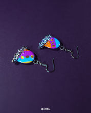 Ufaq multicolor hook earrings, beautifully contrasted against a deep purple backdrop, with a vibrant mix of hues and bold patterns that showcase their playful yet chic design — Muselot.
