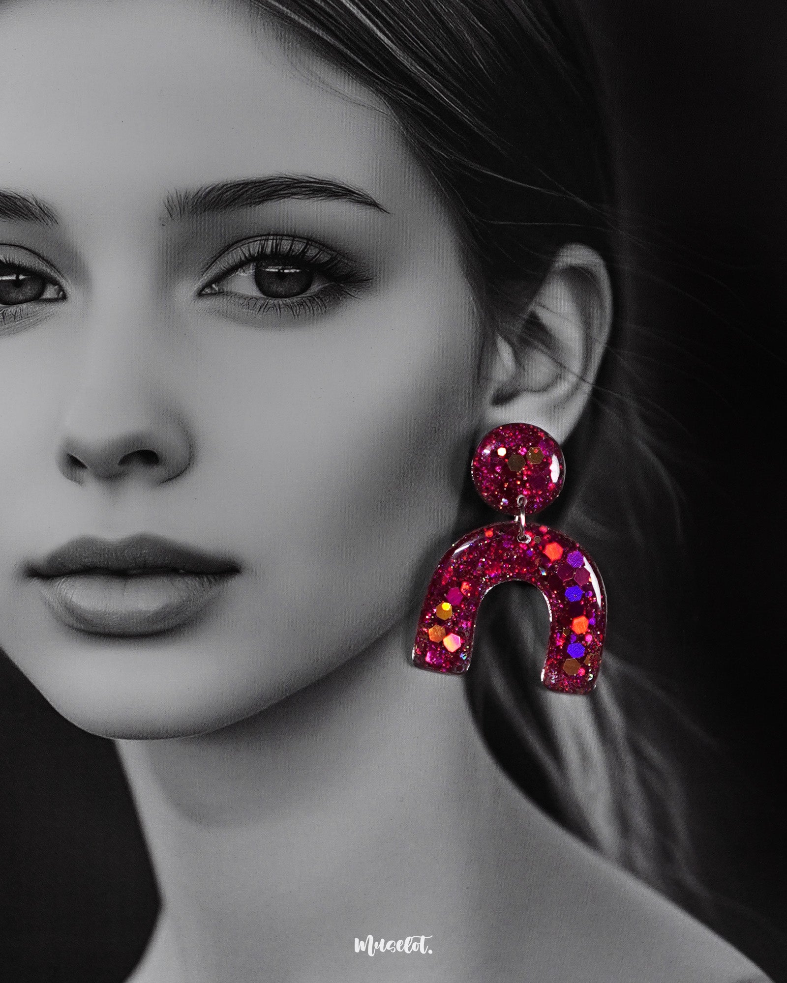 Close-up of model wearing Ulfat resin stud earrings, highlighting the bold pink-purple glitter arch design and glossy finish – Muselot.