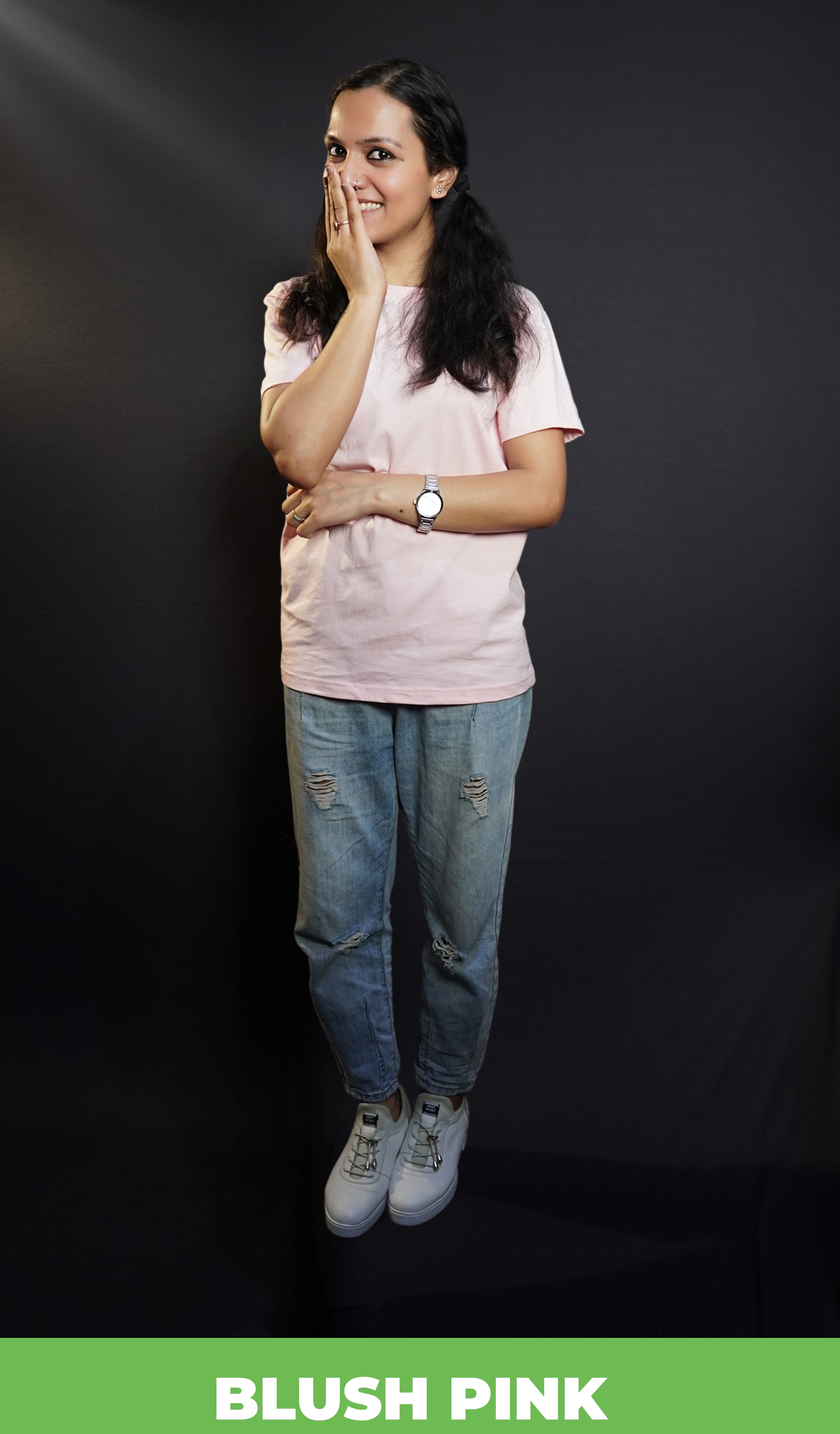A young model wearing a blush pink unisex t shirt with a simple, short-sleeved design, pairing the top with ripped blue jeans, highlighting a casual, everyday look-muselot