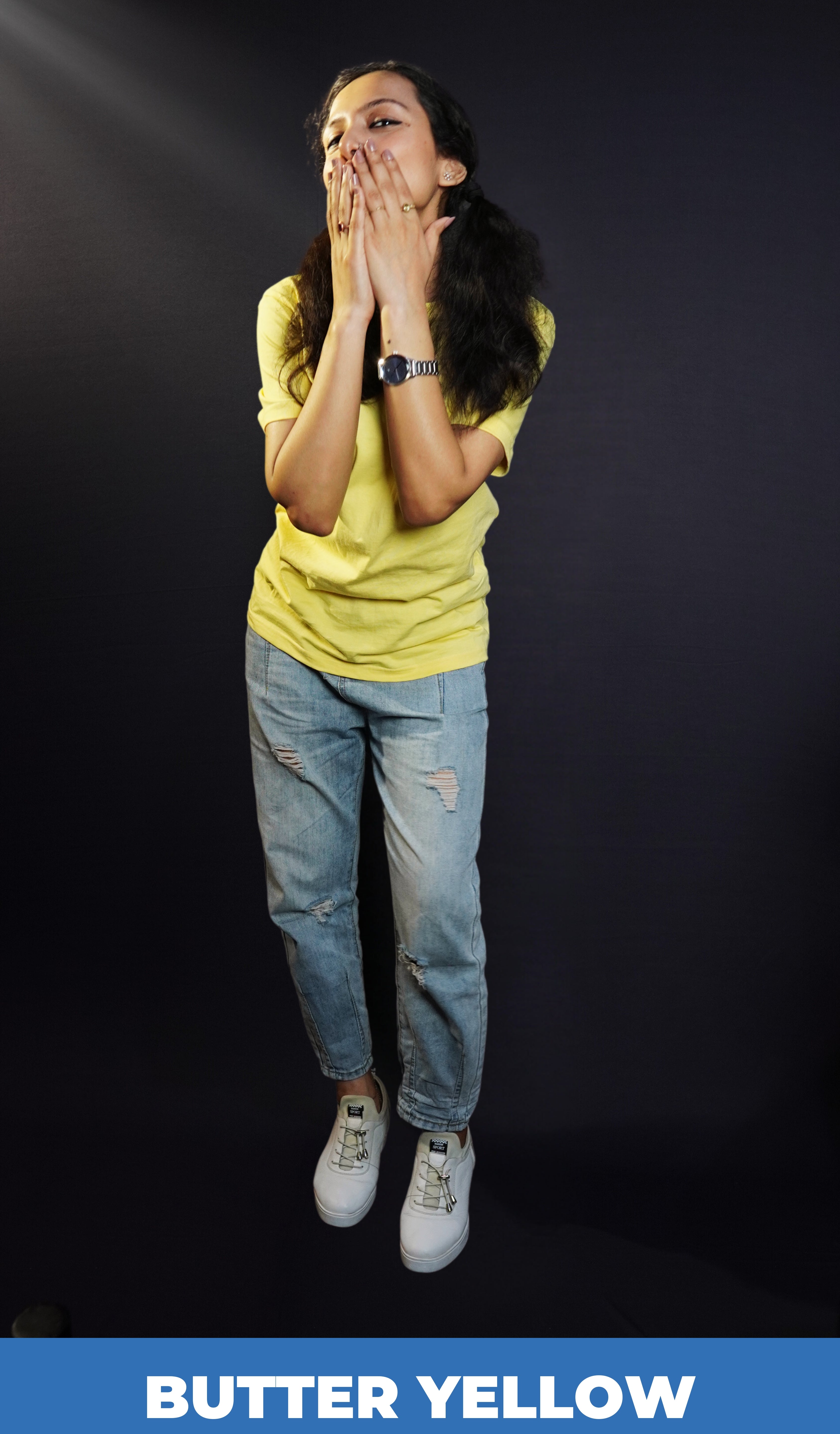 A woman wearing a half sleeved plain round neck sweat resistant butter yellow t-shirt, posing with her hands covering her mouth, highlighting an informal fresh look-Muselot