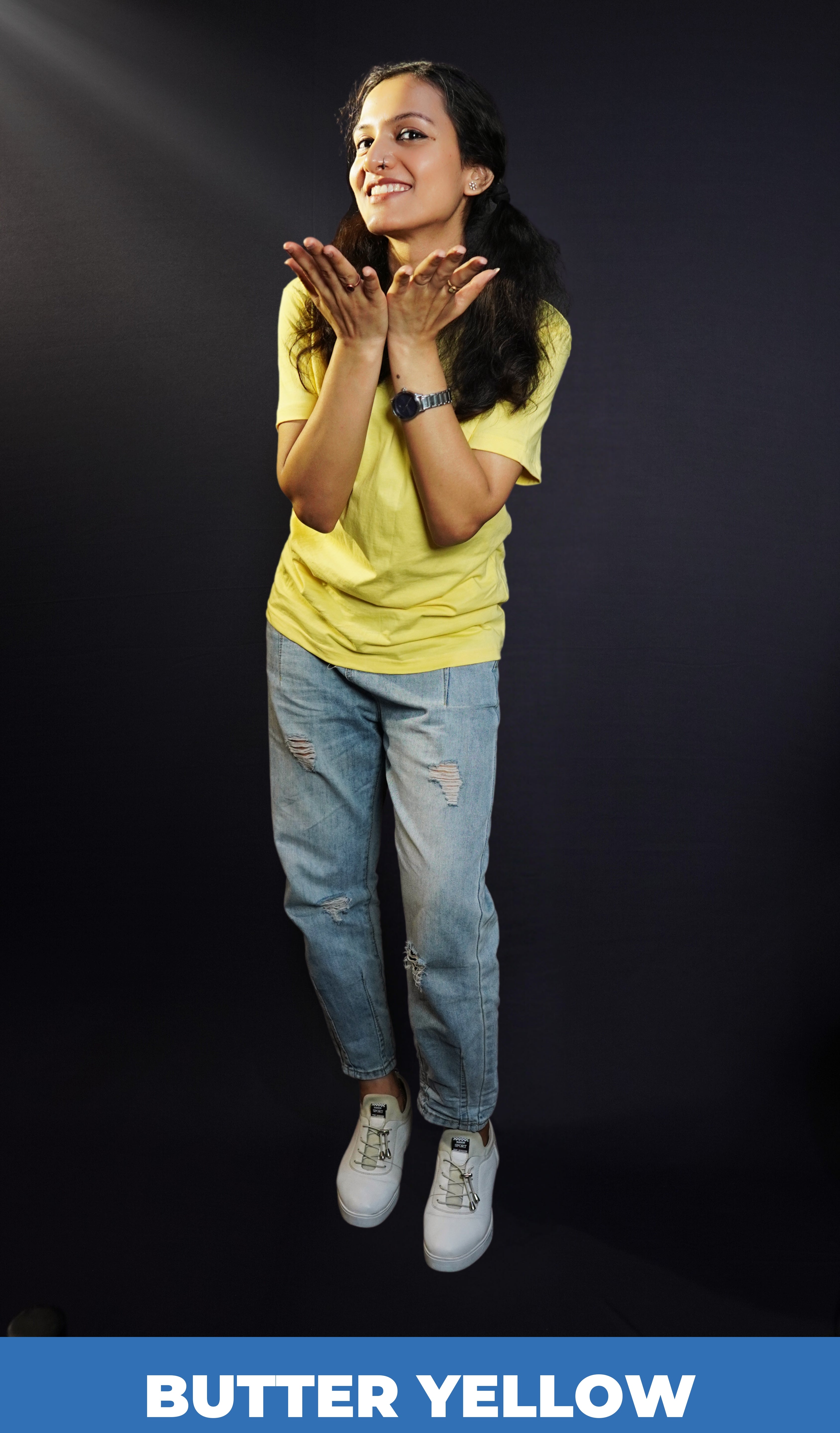 A woman posing happily with her hands directing forward, wearing a long length round neck plain adult's t-shirt, highlighting an elegant drapye look-Muselot