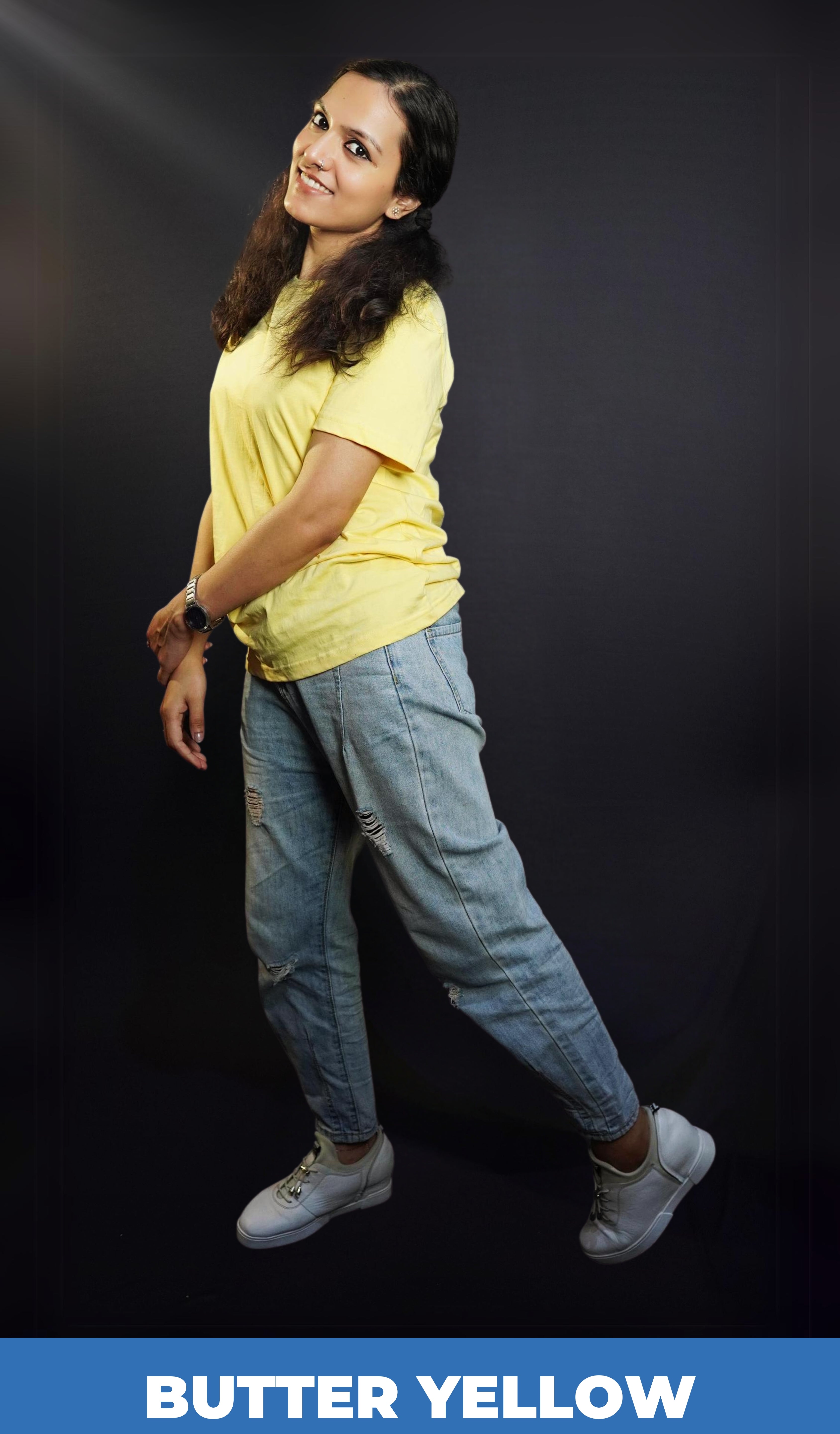 A woman posing happily as she sways sideways, wearing a butter yellow long length plain round neck t-shirt, highlighting a casual cozy look-Muselot