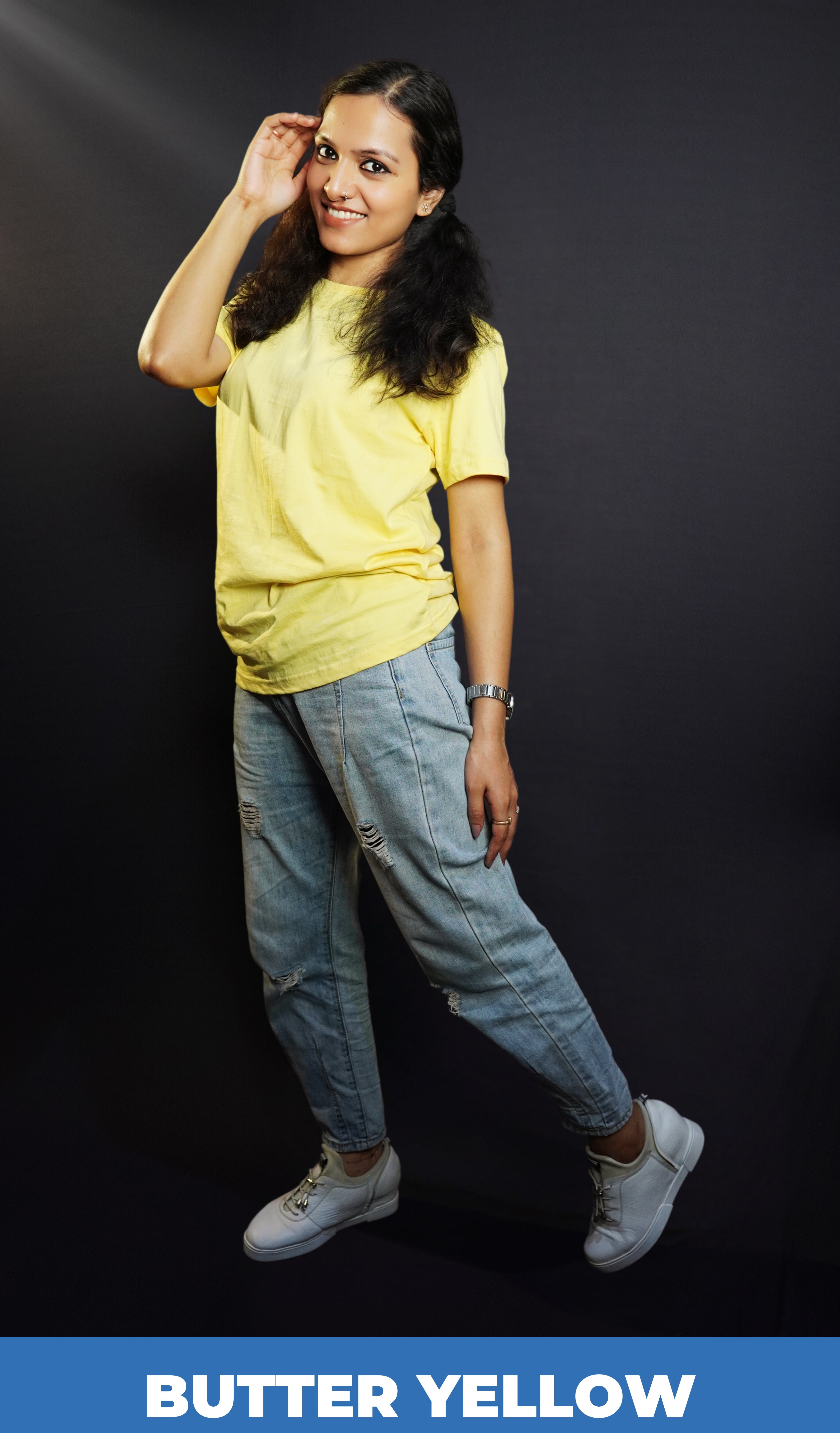 A stylish model posing with her hand on the side of her head as she sways slightly to her side, wearing a comfortable plain plus size unisex butter yellow t-shirt, highlighting a fashionable baggy fit-Muselot