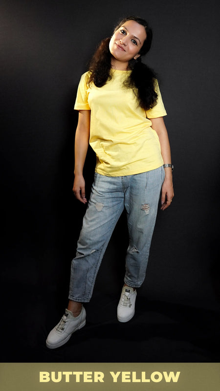 A woman posing as she slightly bend to her side, wearing butter yellow plain quick drying t-shirt, highlighting a cool breathable fit-Muselot