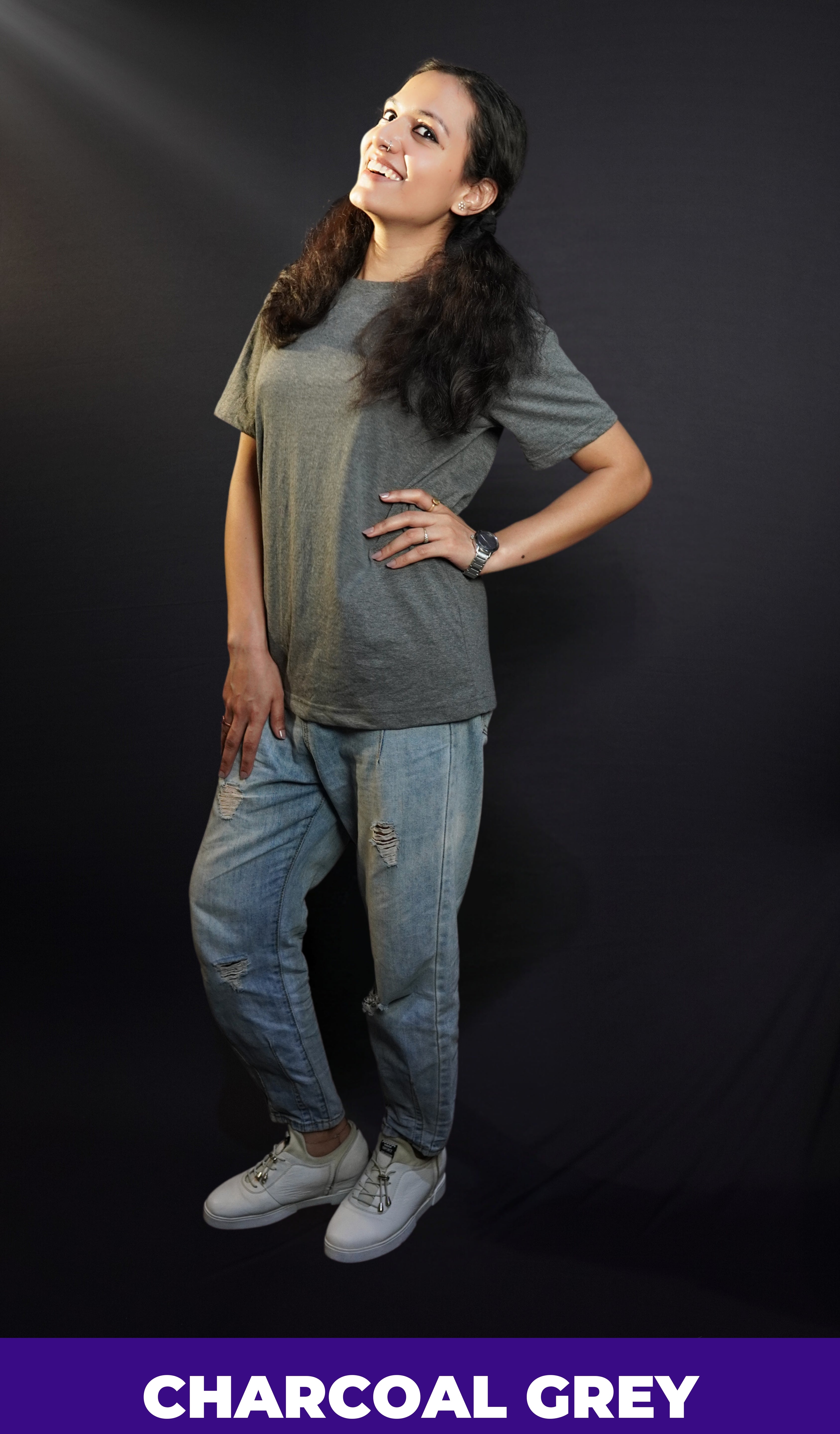 a stylish model in a trendy charcoal grey plain casual t shirt with ripped jeans laughing happily-muselot