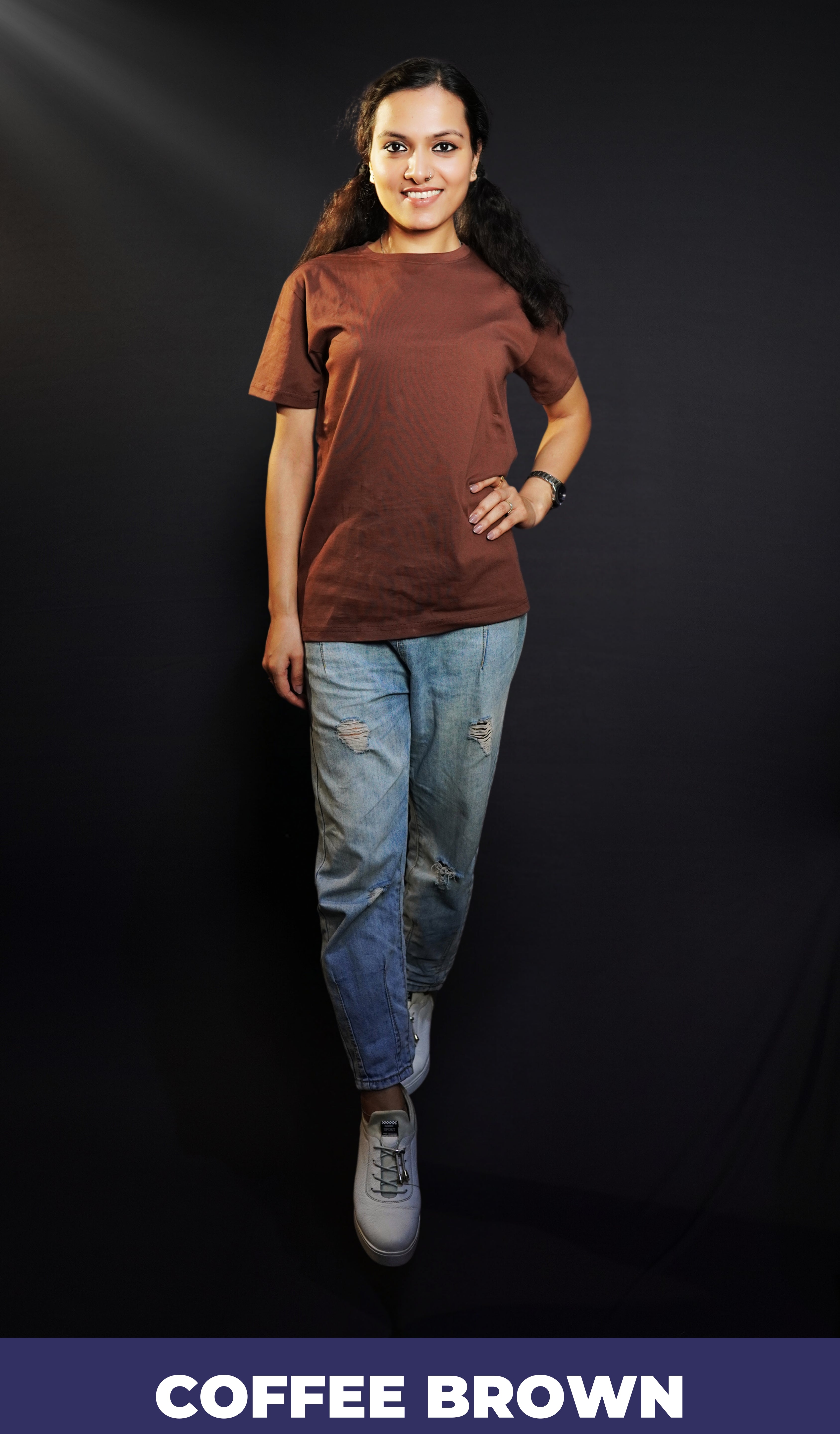 A woman posing happily with her one hand on her waist and other on her side, wearing a round neck plain long length t-shirt, highlighting a soft flexible style-Muselot