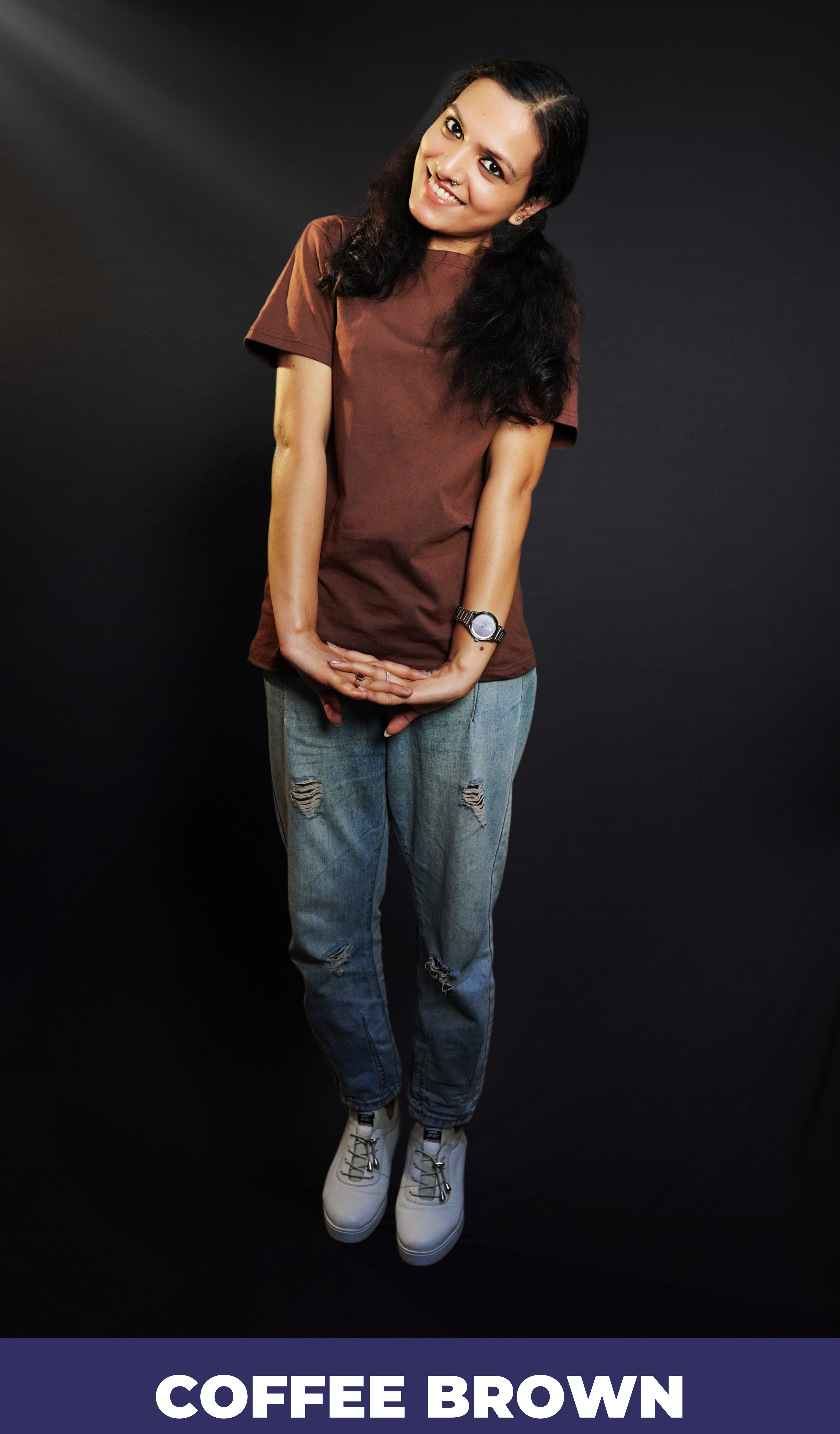 A woman wearing a short sleeved cotton coffee brown plain t-shirt, posing with her hands stretched and fingers intertwined, highlighting a fashionable casual fit-Muselot