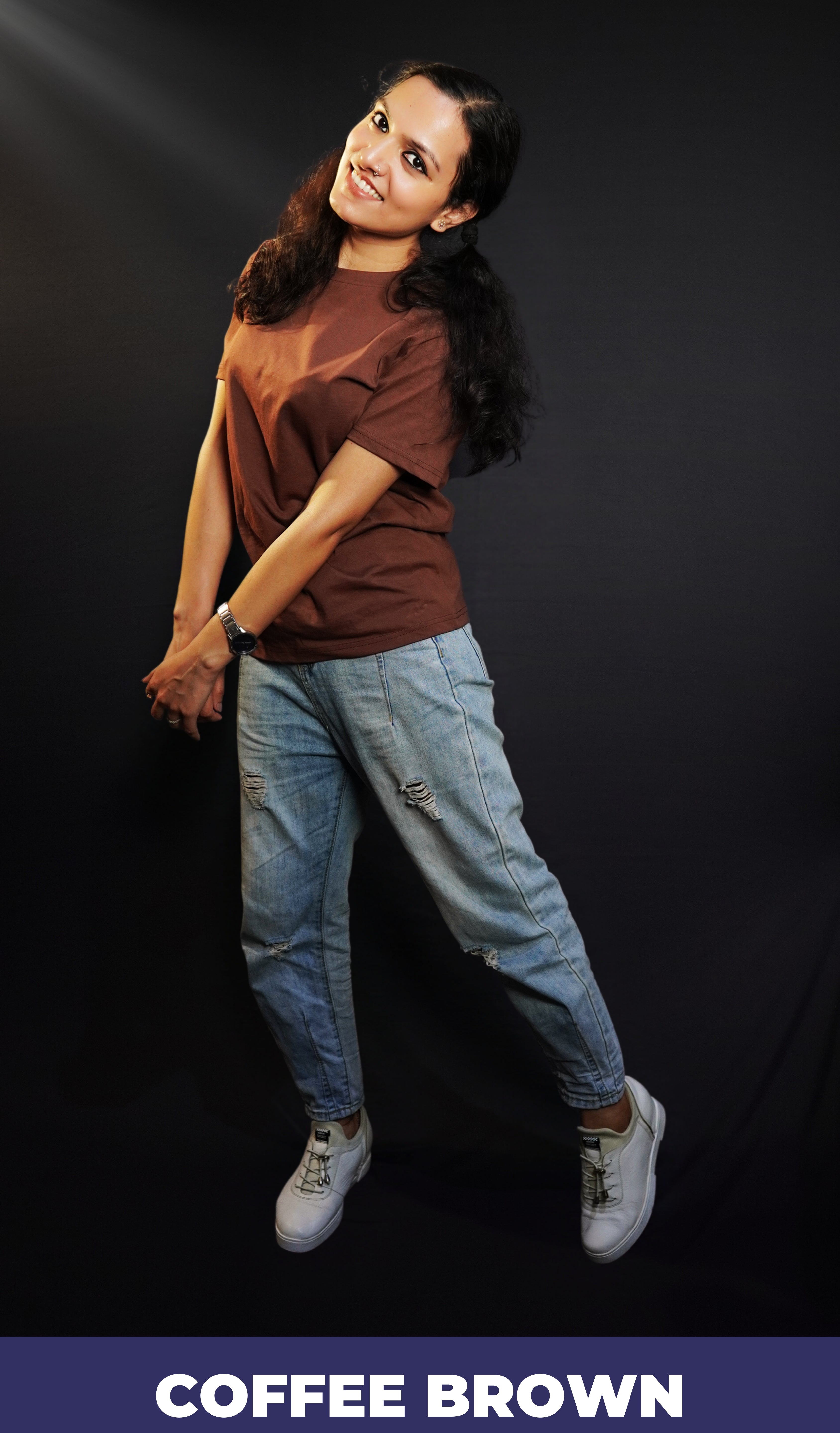 A woman posing happily as she sways sideways with her head bent backward, wearing a unisex stretchable round neck coffee brown t-shirt, showcasing a perfect fit style-Muselot