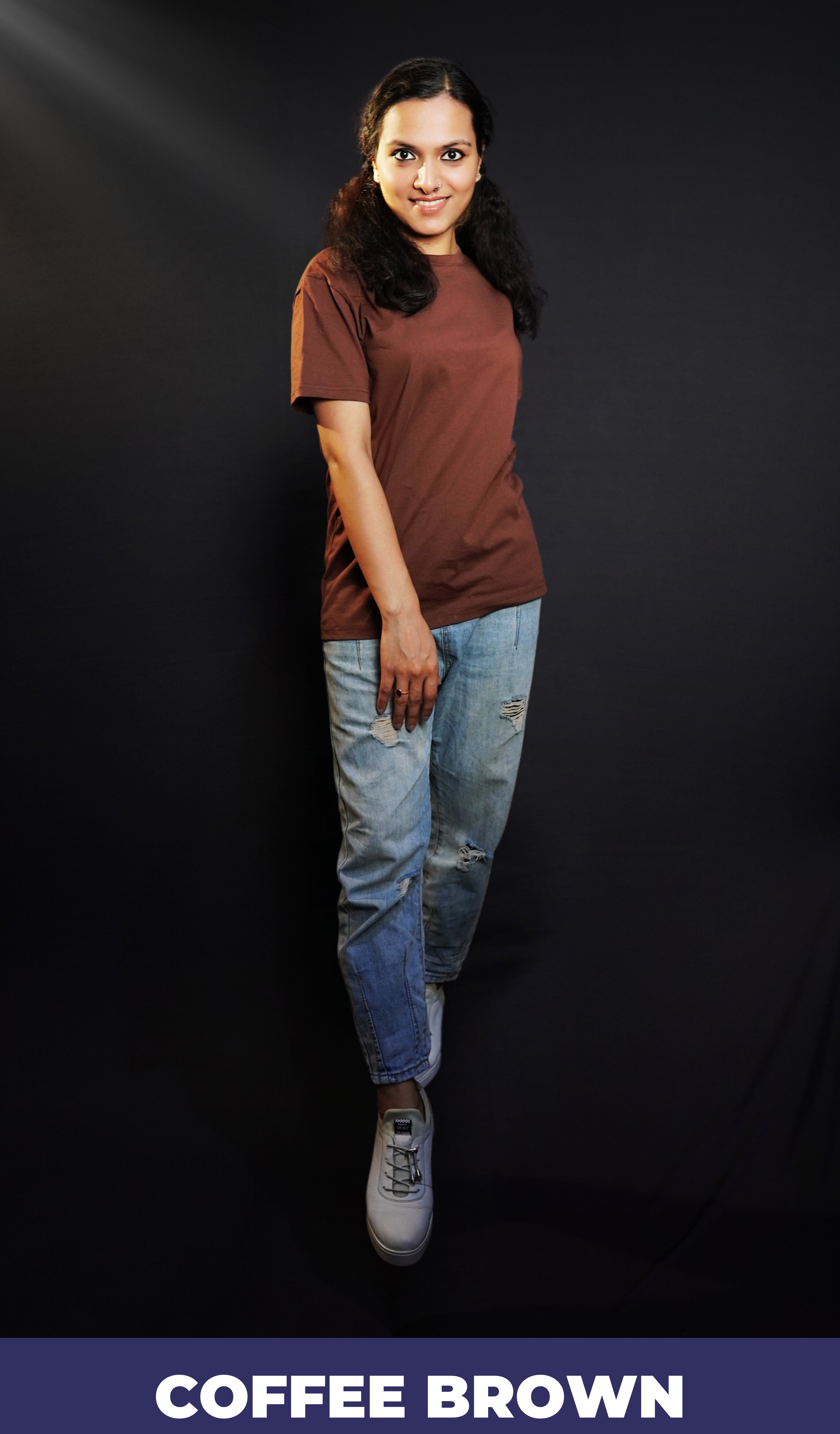 An elegant model posing with her one hand on top of her thigh and other behind her, wearing a cotton unisex plus size summer coffee brown t-shirt, showcasing a modish laid back fit-Muselot