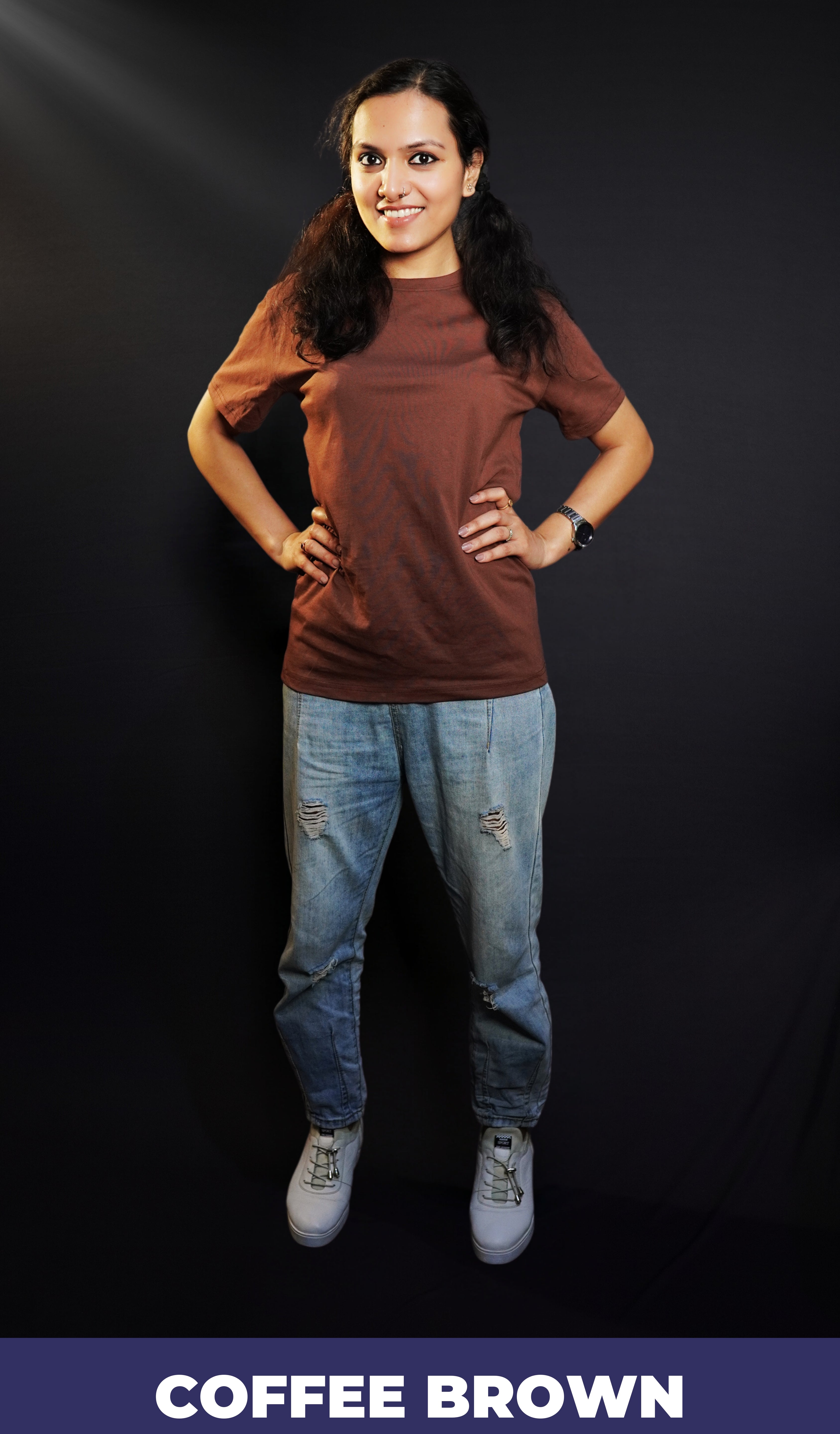A woman wearing a long plain round neck coffee brown t-shirt, posing with her hands on the sides of her waist, showcasing a flowing voguish style-Muselot