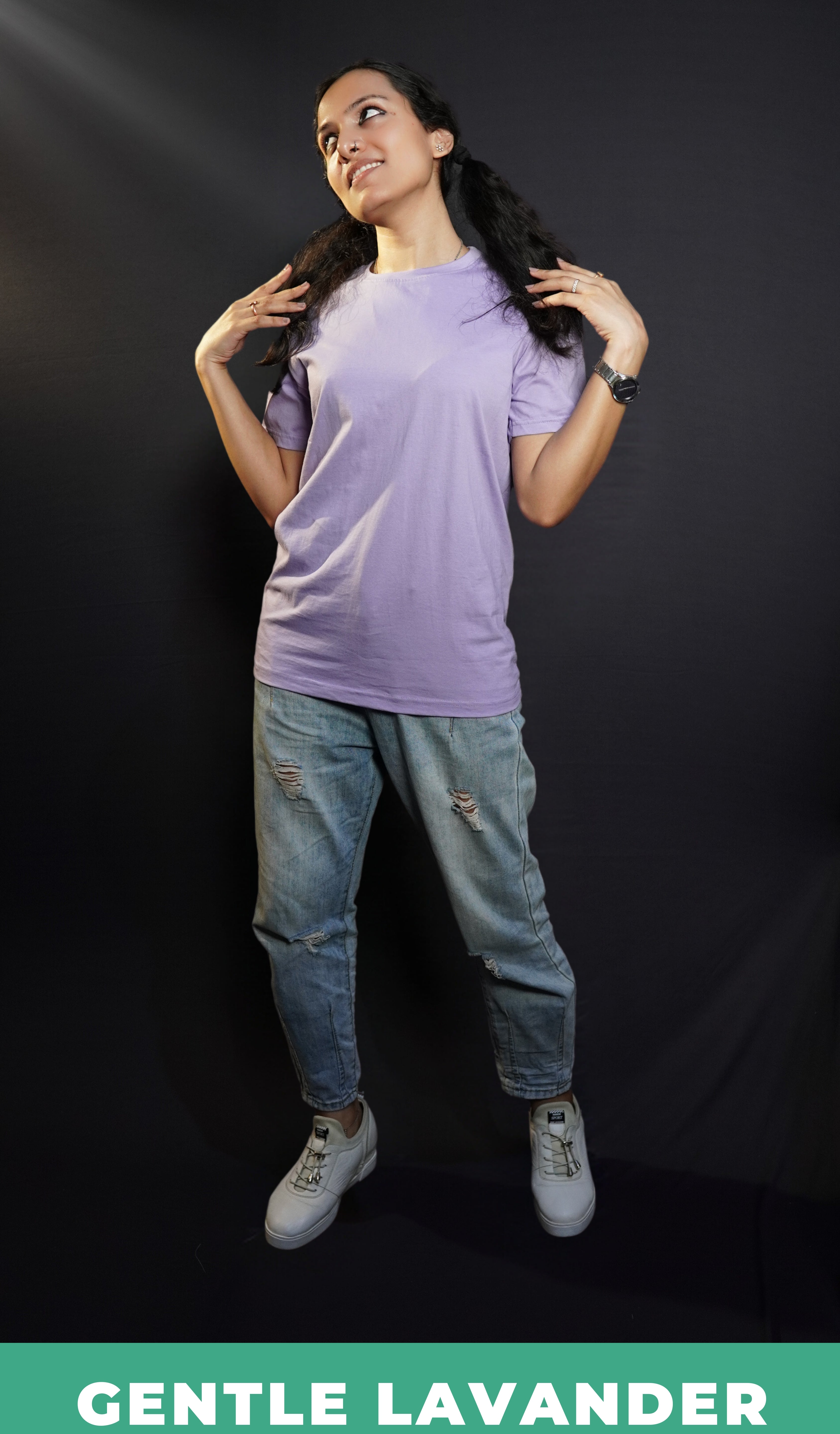 A woman wearing a plain adults round neck cotton gentle lavender t-shirt, posing with her short hair covering her shoulder and her hands sitting gently upon them, highlighting a stylish snug fit-Muselot