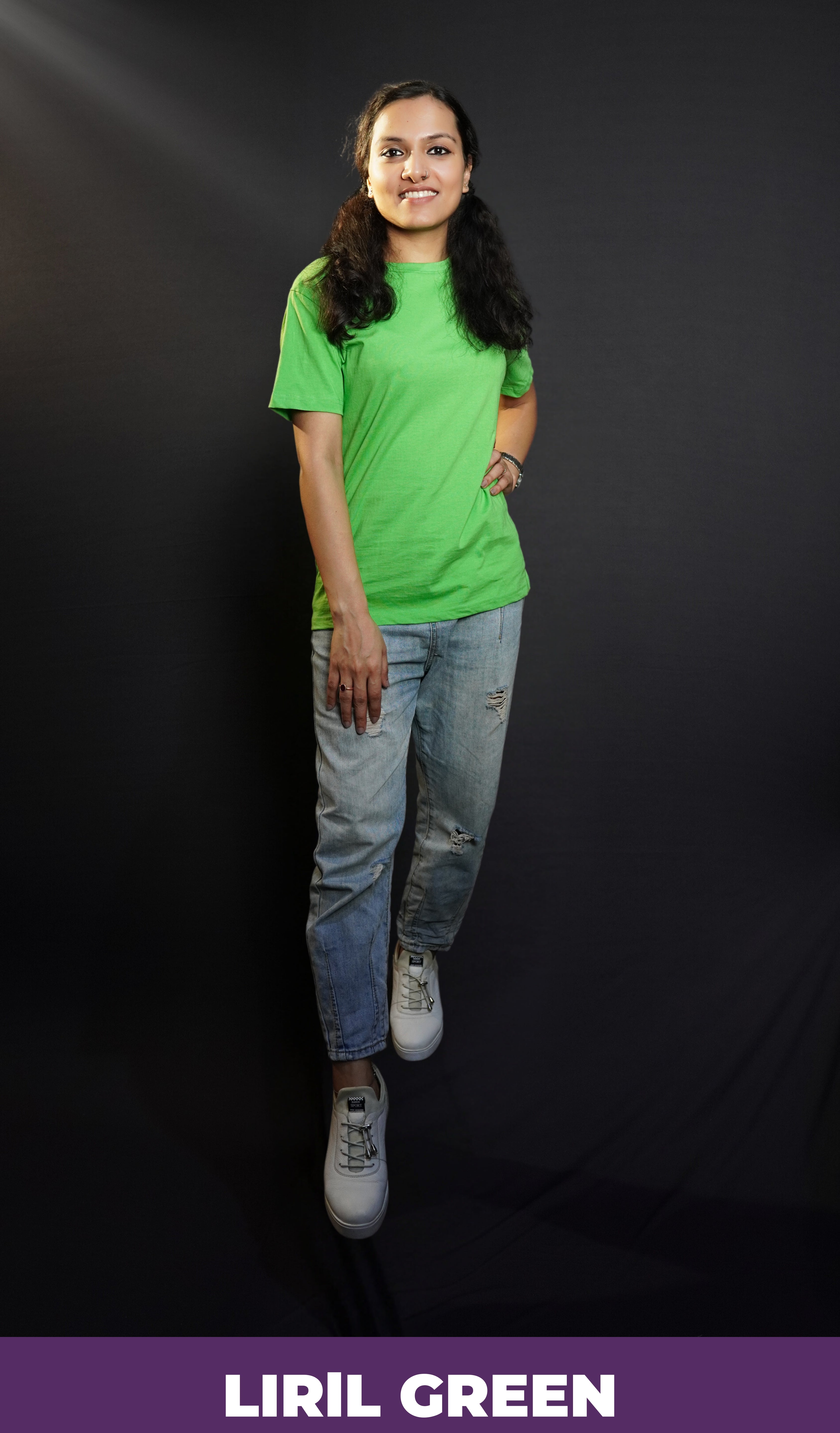 An elegant model wearing a liril green quick drying plain long length t-shirt, posing confidently with her hand on her waist and another on her thigh, smiling brightly, showcasing a modern informal look-Muselot