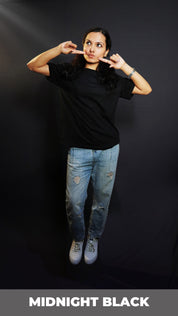 A woman in a plain adult's midnight black t-shirt with round neck, short sleeves and long length, posing with her fingers poking her cheeks, pouting a little, highlighting a cute informal look-Muselot