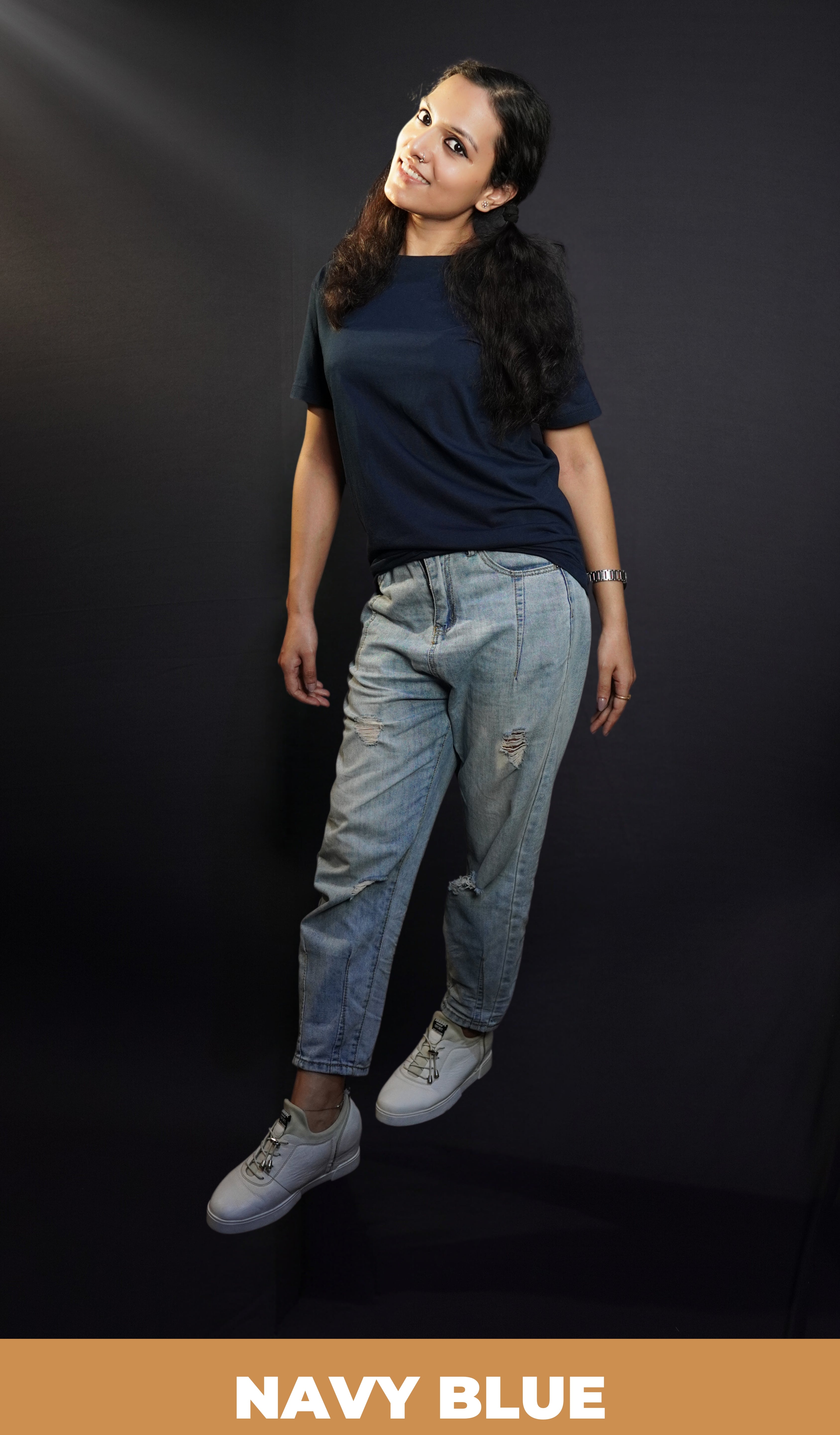 A woman wearing a girl's plain cotton round neck long length navy blue t-shirt, posing with her hands hanging on her sides, showcasing a popular relaxed fit-Muselot