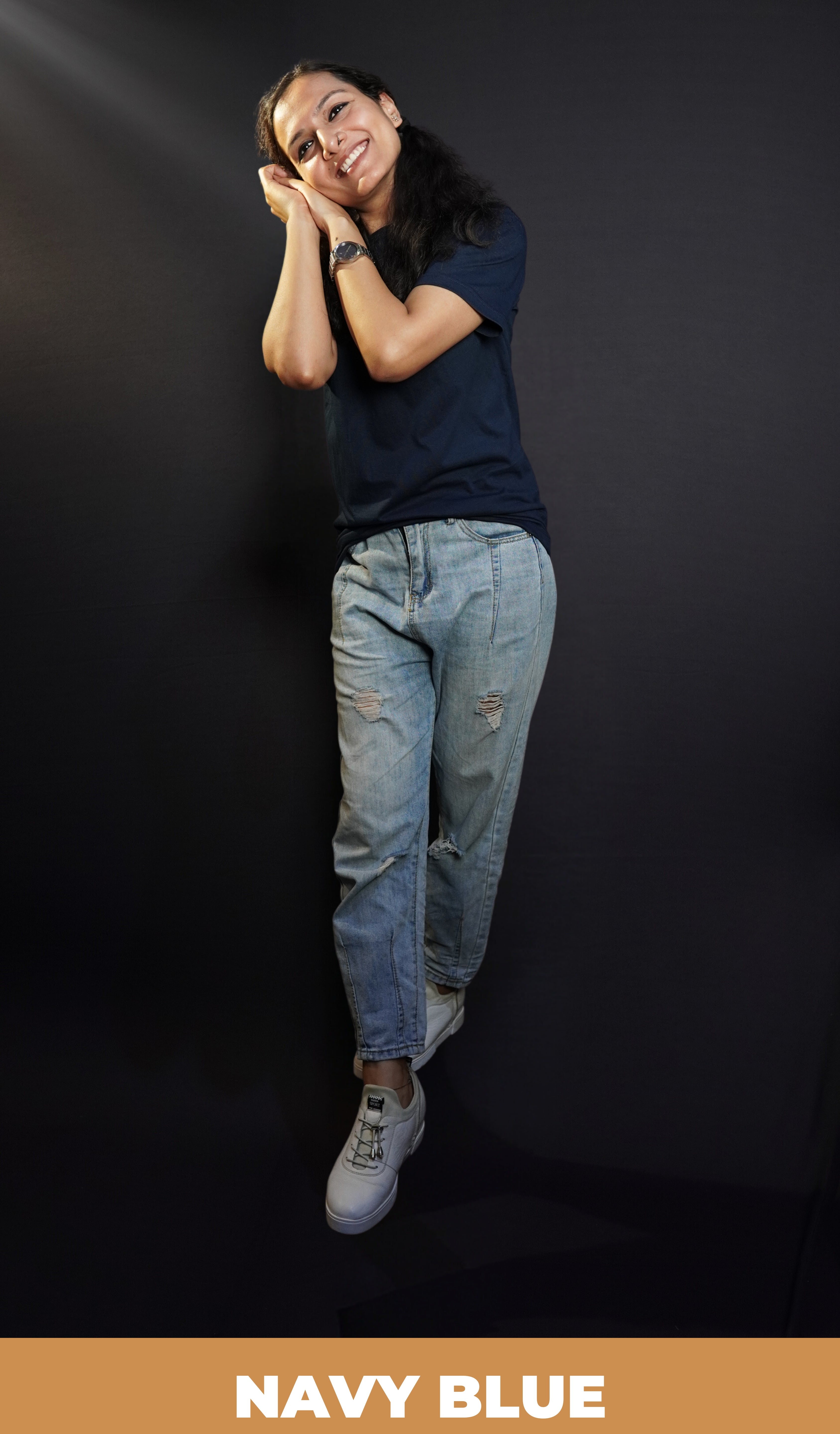 A woman wearing a long length plus size cotton summer navy blue t-shirt, posing with her hands making a pillow below her cheek, showcasing a swank loose fit-Muselot