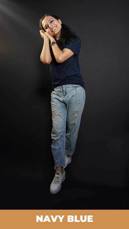 A woman wearing a long length plus size cotton summer navy blue t-shirt, posing with her hands making a pillow below her cheek, showcasing a swank loose fit-Muselot