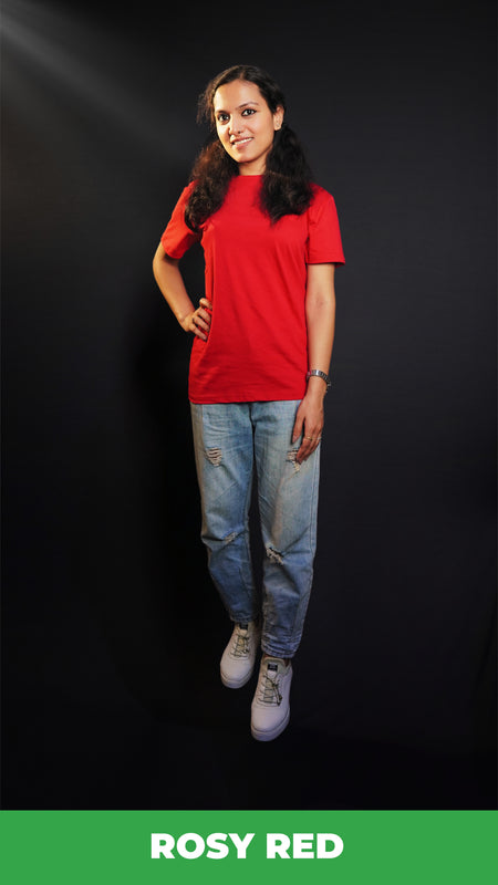 A stylish model standing straight as her hand hangs on her side and another on her waist, wearing a unisex plain rosy red round neck t-shirt. showcasing a fashionable in vogue look-Muselot