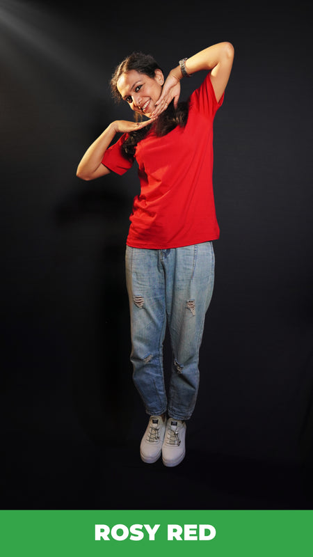A happy woman wearing an adult's summer round neck moisture wicking rosy red t-shirt, posing with her hands below her chin, smiling happily, highlighting an aesthetic cozy look-Muselot