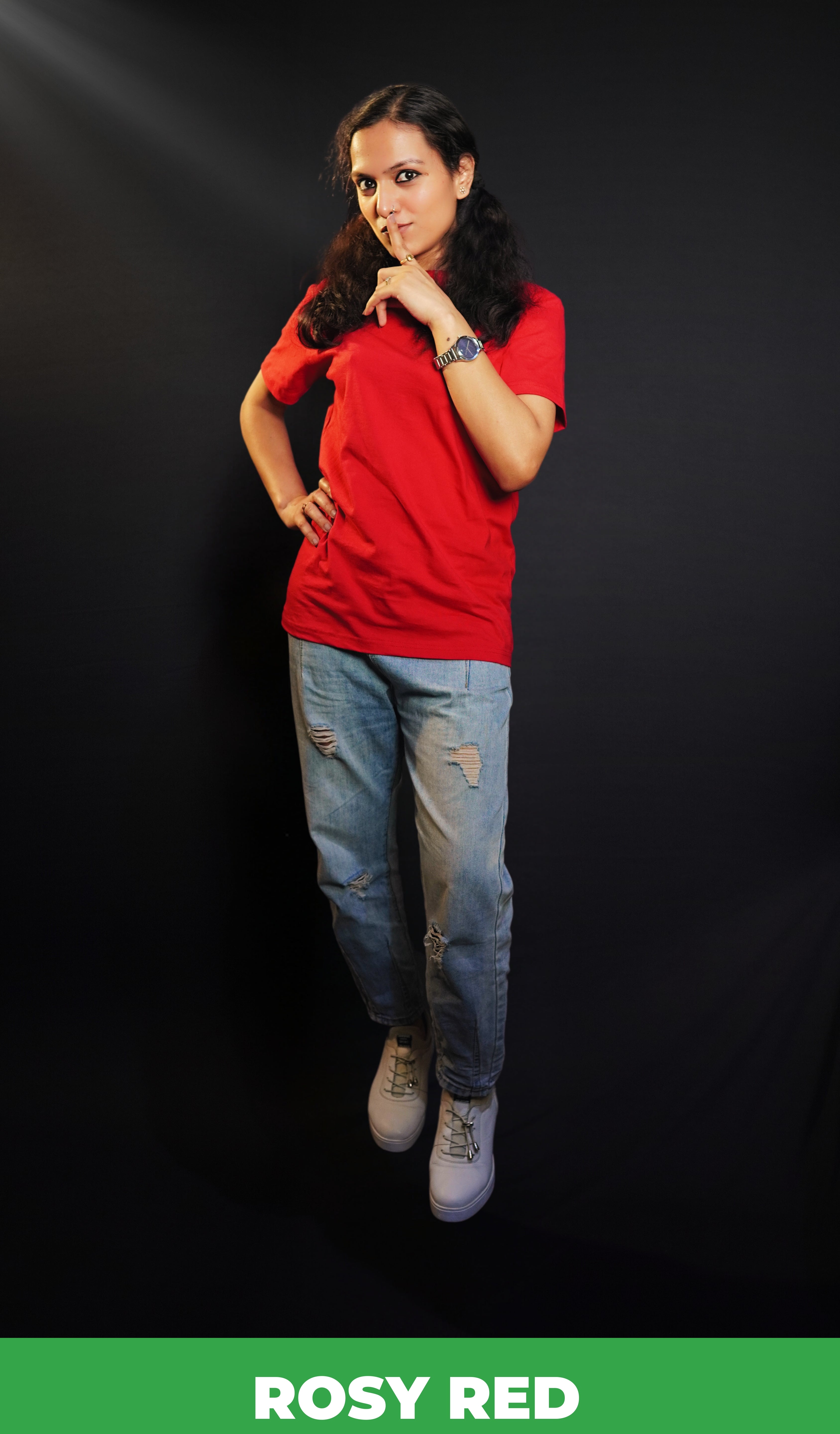 A woman posing with her finger on her lips and a hand on her waist, wearing a plus size round neck stretchable rosy red t-shirt, showcasing a popular easygoing fit-Muselot