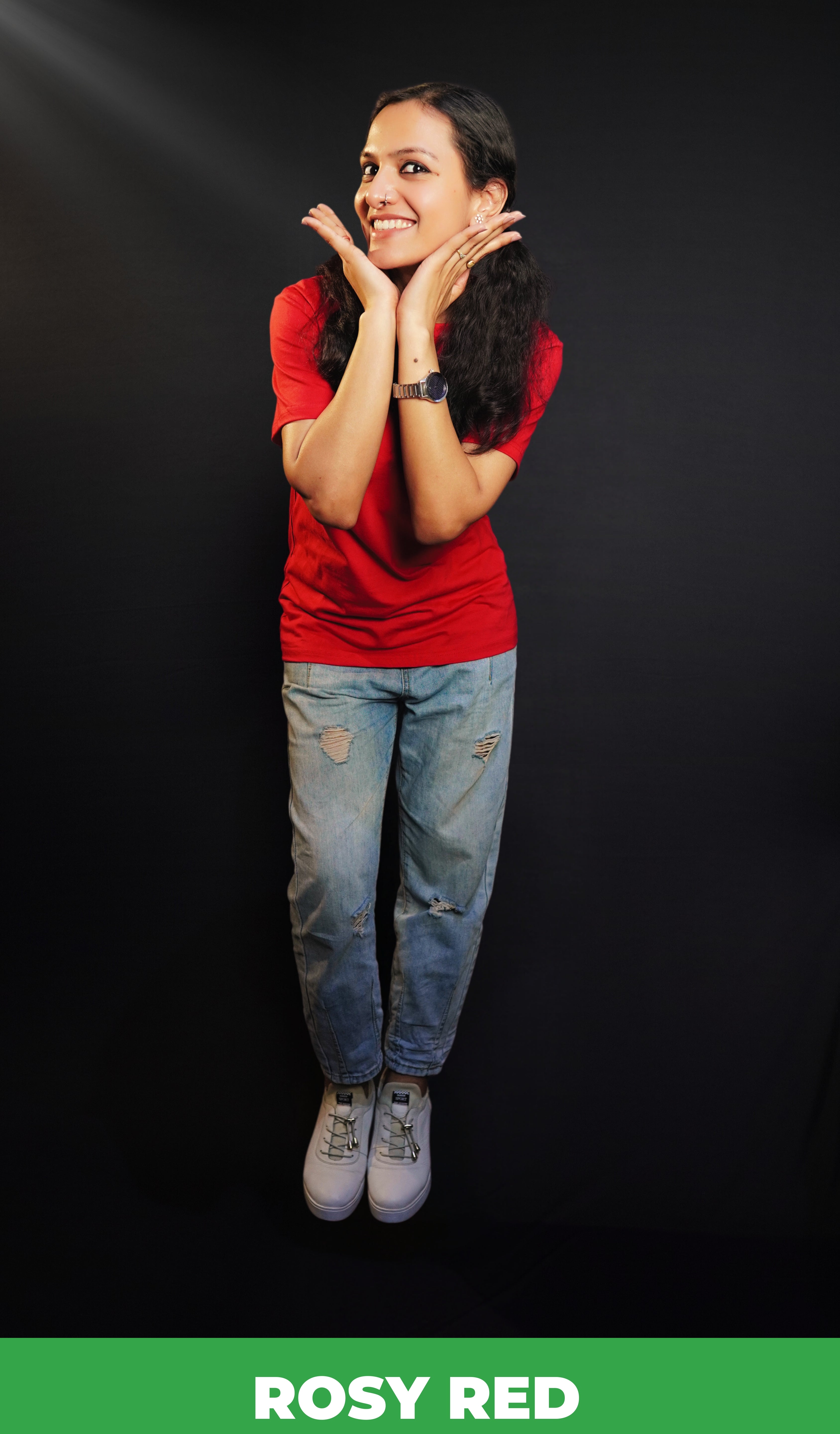 A woman posing happily with her hands under her chin as she bends slightly forward, wearing a summer rosy red t-shirt with round neck and short sleeves, highlighting a casual cozy fit-Muselot