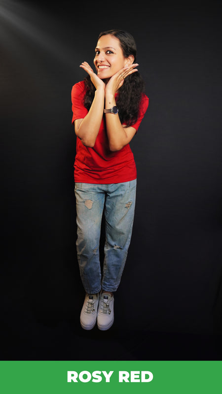 A woman posing happily with her hands under her chin as she bends slightly forward, wearing a summer rosy red t-shirt with round neck and short sleeves, highlighting a casual cozy fit-Muselot