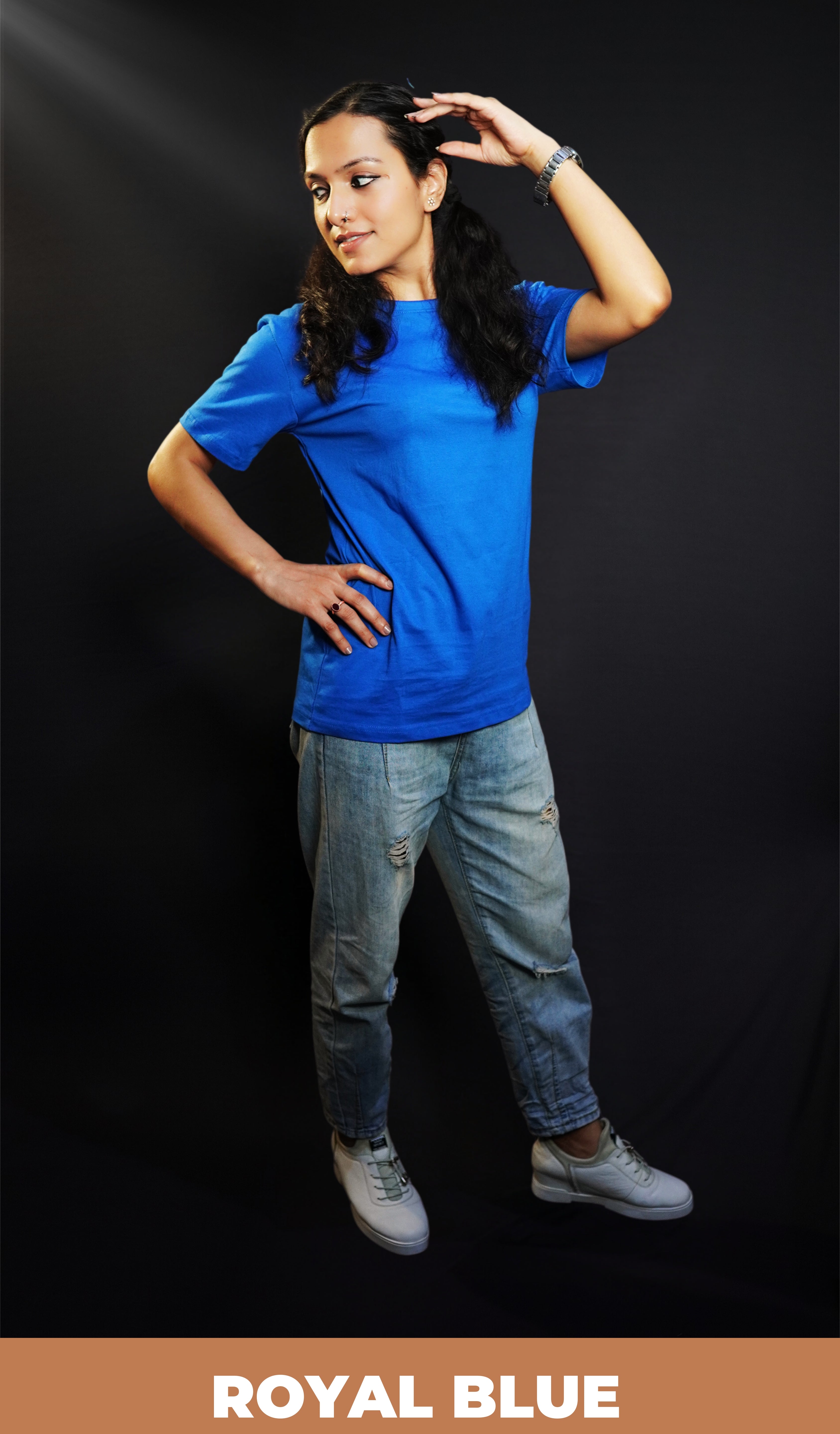 A woman wearing a unisex plain cotton round neck royal blue t-shirt, posing with her hand on her head and another on her waist as she looks sideways, highlighting a summer casual fit-Muselot