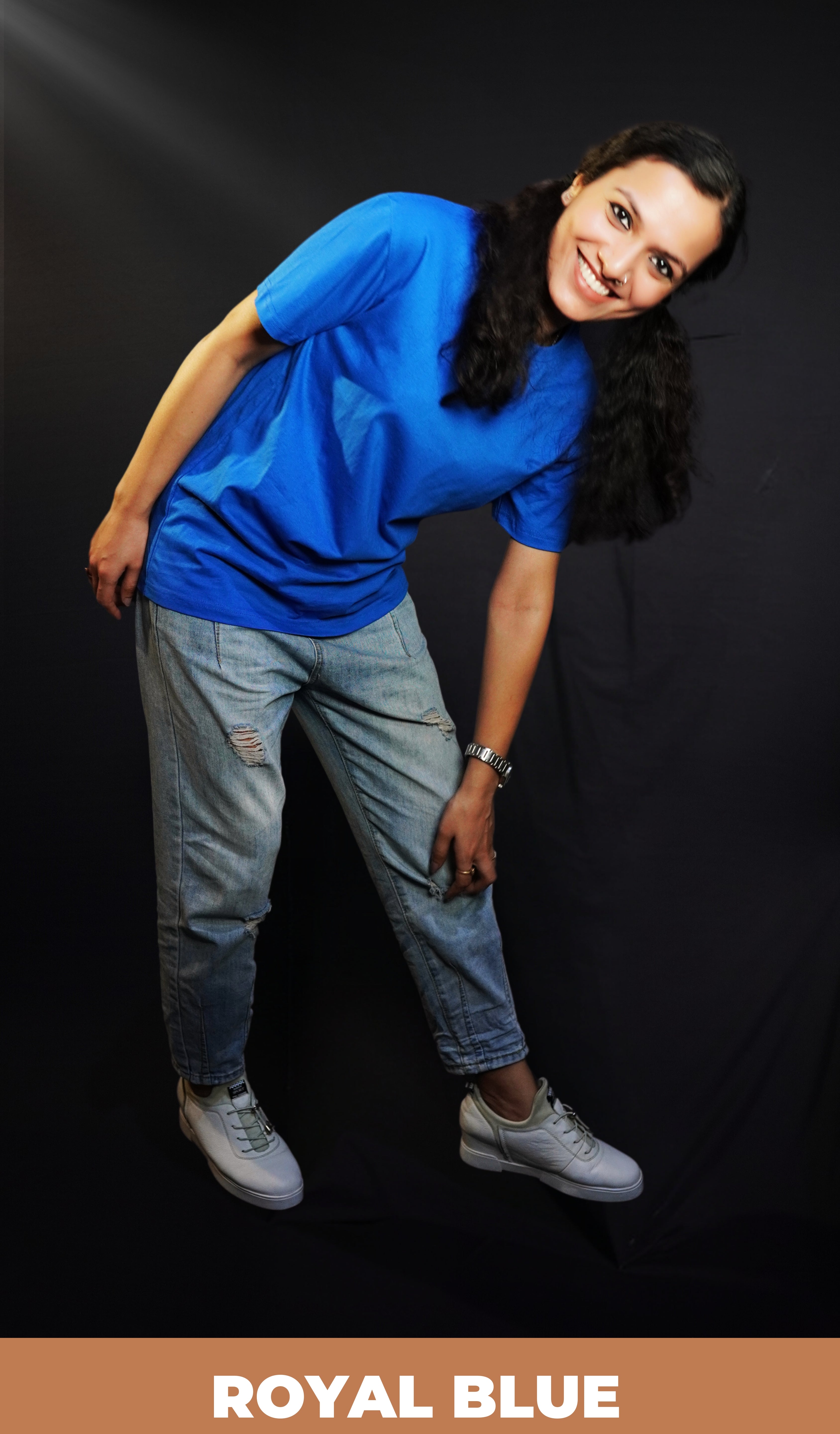 A woman bending forward with her hand touching her knee smiling brightly, wearing a women's round neck short sleeved royal blue t-shirt, showcasing a comfortable snug fit-Muselot