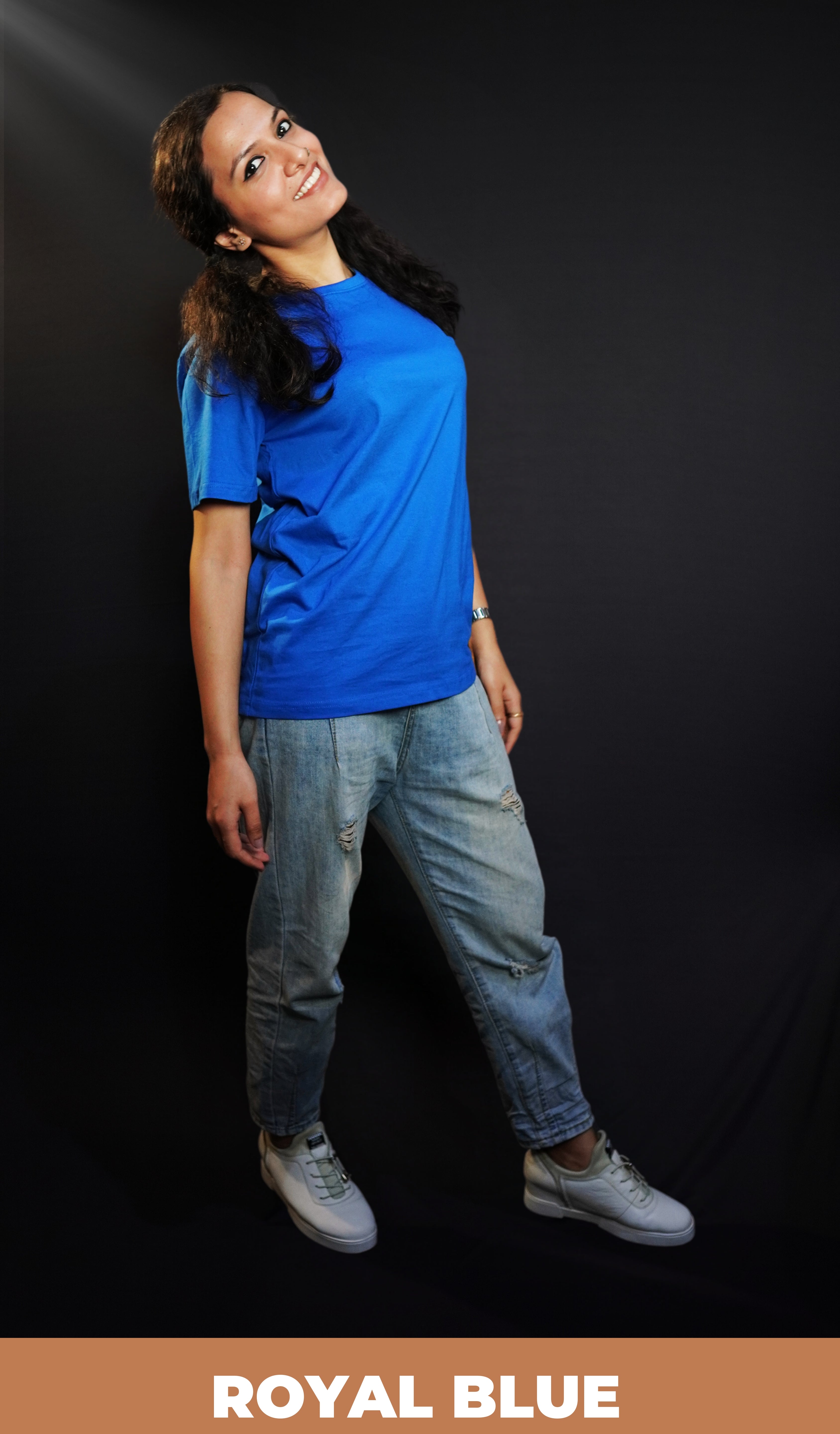 A woman wearing men's plain cotton stretchable royal blue t-shirt, posing as she stands slightly backwards with her hands hanging on her sides, highlighting a relaxed everyday look-Muselot