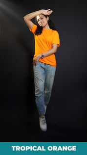 A stylish model posing with her hand upon her forehead and other gently hugging her sideways, wearing a men's plus size long length plain orange t-shirt, highlighting a stylish in vogue look-Muselot