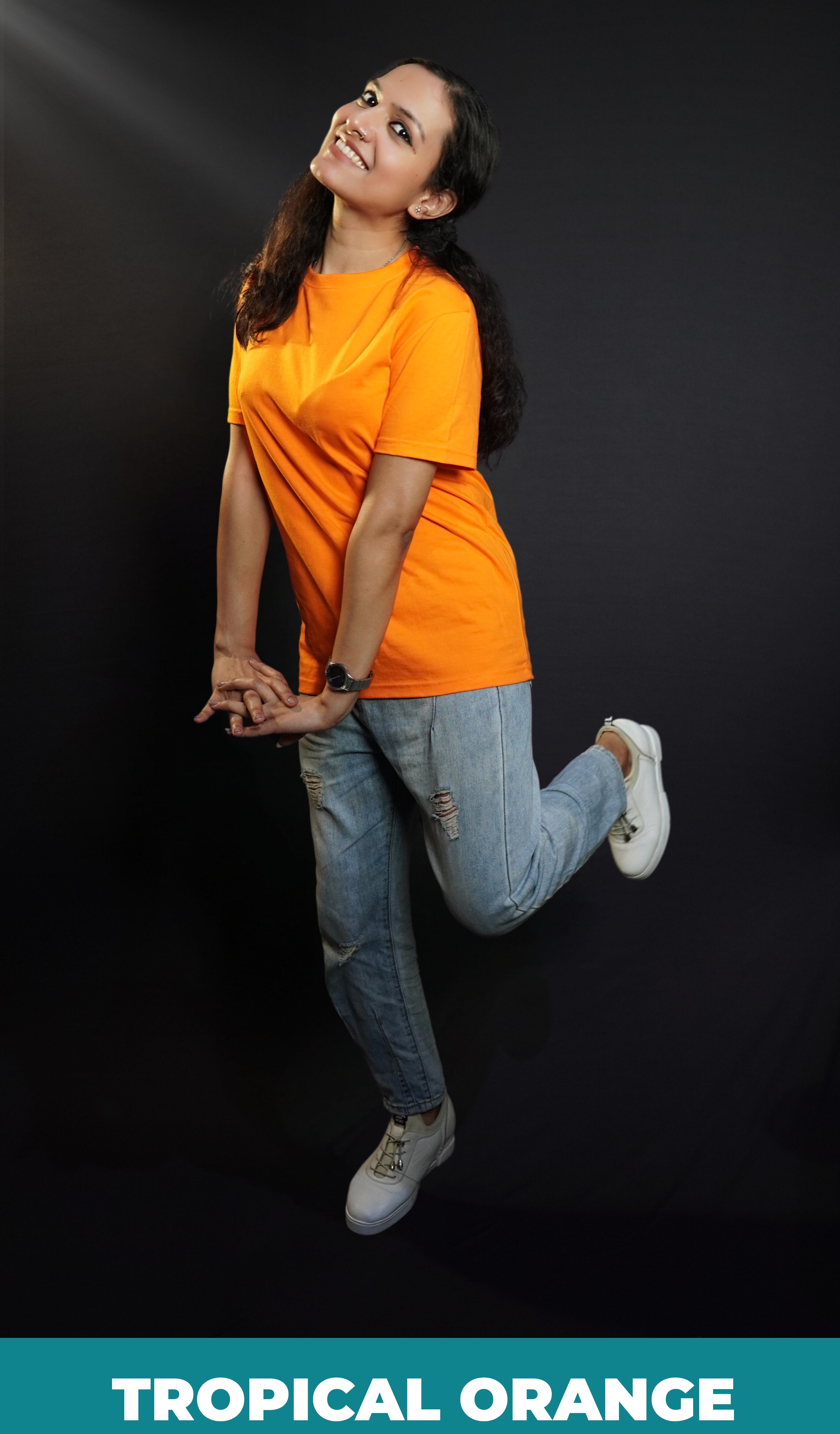 A happy woman wearing a plain moisture wicking round neck girl's t-shirt, posing with her hands stretched in front of her with fingers intertwined with each other, showcasing a comfortable snug fit-Muselot