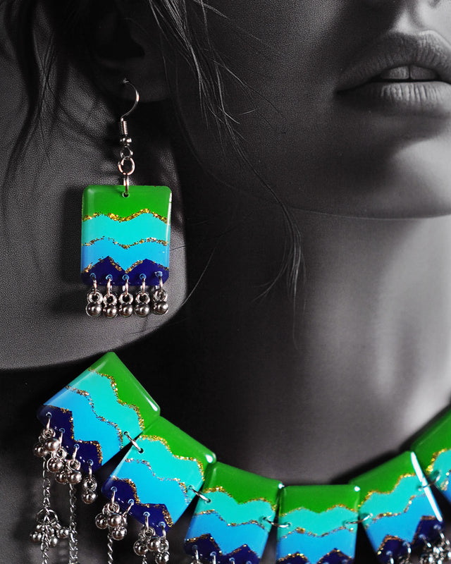 Close-up shot of the Waterfall Boho earrings featuring green, aqua, and blue enamel panels with glitter detailing, finished with silver clustered beads that add a playful, boho touch — Muselot.