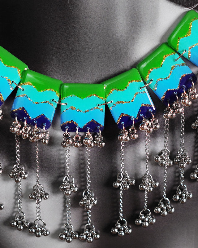 A close-up shot of a woman wearing the waterfall boho jewelry set, focusing on the layered arrangement and elements and cascading beads gracefully resting on her neckline, showcasing the artisanal detail and vibrant charm of this statement piece — Muselot.