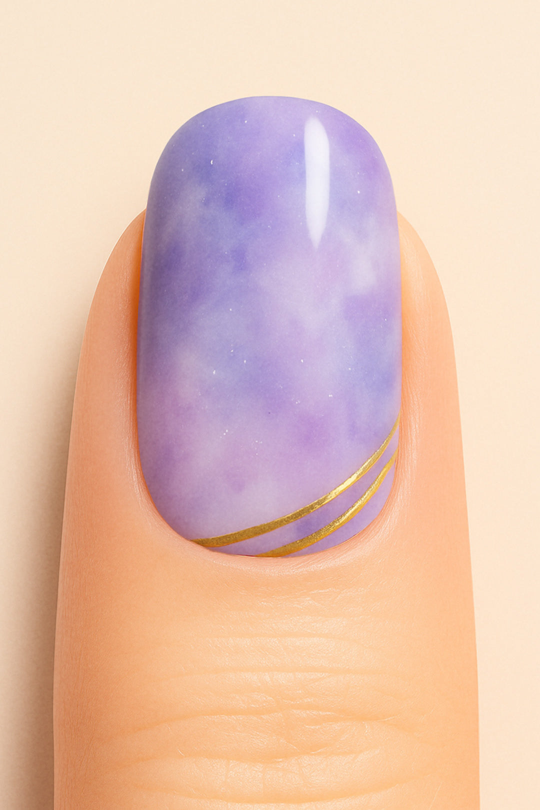 A close-up shot of a model’s finger featuring Wavy Dream Marble Nail Stickies, designed with a dreamy purple marble effect accented by fine white patterns and elegant golden wave lines near the tip, giving a soft yet luxurious finish to the nail art-Muselot