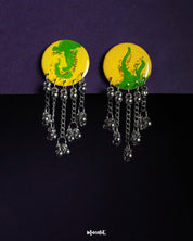 The Zarangi drop chain earrings feature a bold yellow and green hand-painted circular top, with cascading silver-toned chains and ghungroo beads, highlighting the vibrant fusion of color and movement while showcasing handcrafted artistry — Muselot.
