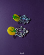 Side view of the Zarangi yellow drop earrings showcasing their round, hand-painted yellow tops with green abstract motifs, and silver-toned chain tassels with jingling ghungroo details — Muselot.