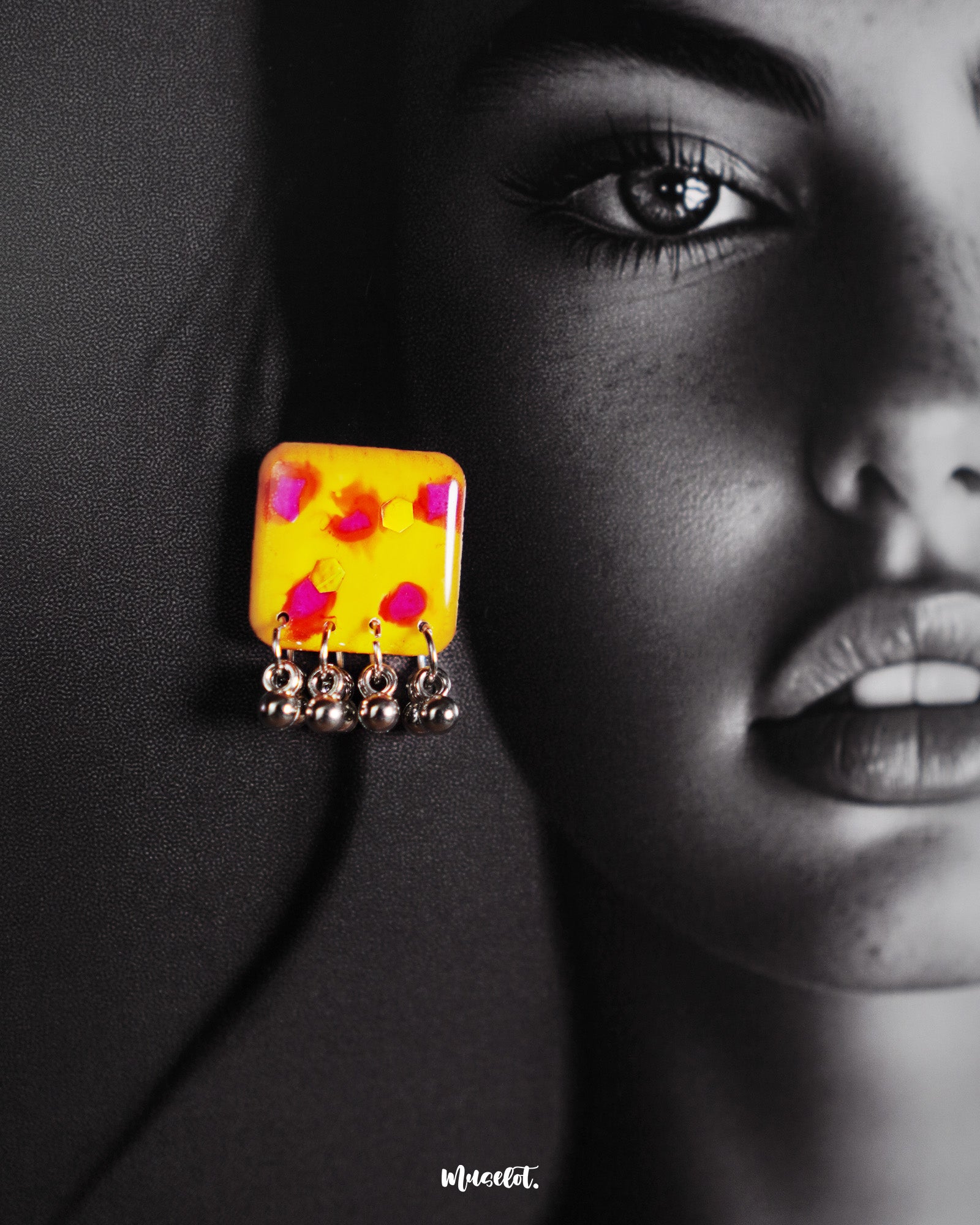 Close-up of model wearing Zard Bahaar earrings, showcasing yellow hand-painted square studs with pink-red floral accents and silver ghungroo drops – Muselot.