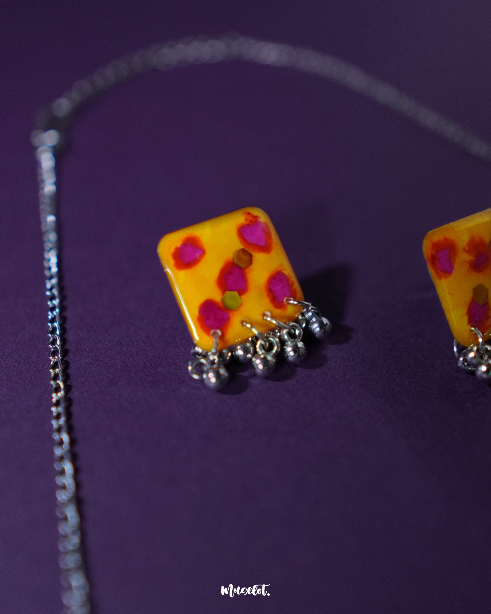 Close-up of Zard Bahaar earring, showcasing the yellow hand-painted floral tile with pink-red accents and silver ghungroo drop detailing – Muselot.