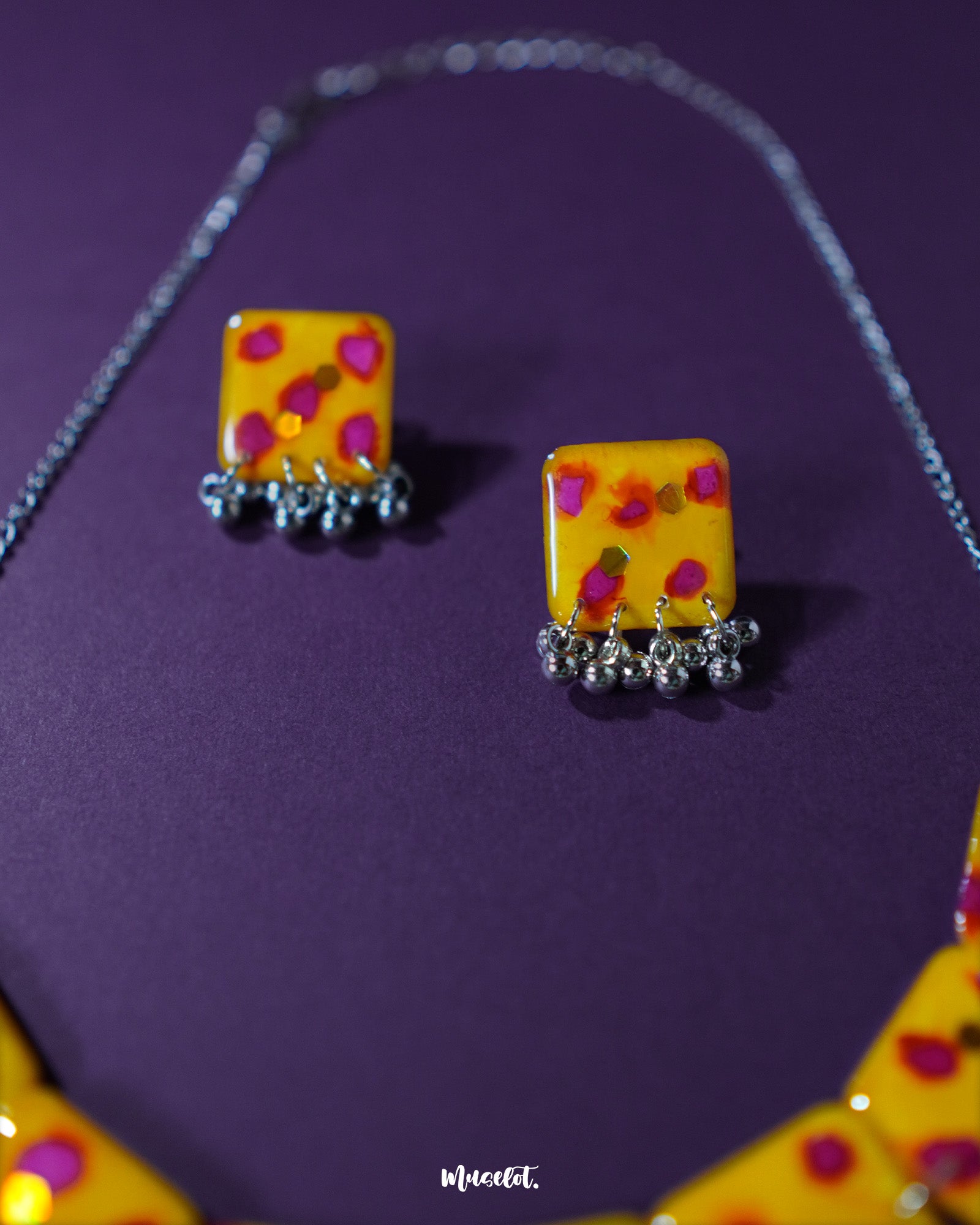 Front view of Zard Bahaar yellow floral jewelry set, showcasing hand-painted square pendants with pink-red accents and coordinated earrings with silver ghungroo details – Muselot.