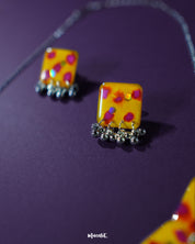 Pair of Zard Bahaar earrings, showcasing yellow hand-painted floral studs with pink-red accents and dangling silver ghungroo details on a plain background – Muselot.