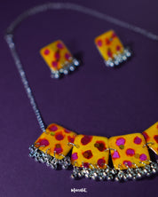 Full Zard Bahaar yellow floral jewelry set with necklace and earrings, highlighting hand-painted tiles and silver ghungroo accents, displayed against a clean background – Muselot.