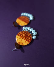 Close-up of Zardozi traditional handmade earrings showcasing detailed embroidery in mustard and rust tones, with delicate white bead drops, highlighting the intricate craftsmanship and rich cultural design — Muselot.