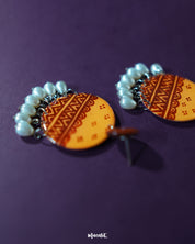 Zardozi traditional handmade earrings placed on a warm-toned backdrop, highlighting the elaborate threadwork in earthy hues and showcasing the classic elegance of Indian heritage craftsmanship — Muselot.
