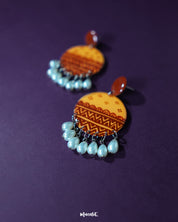 A close-up of Zardozi traditional handmade earrings featuring detailed embroidery in muted reds and golds, highlighting the fine artisanal work and showcasing timeless ethnic charm — Muselot.